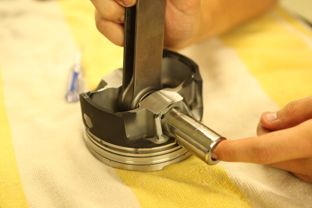 008-1024x683-1 wrist pin being installed on a piston assembly